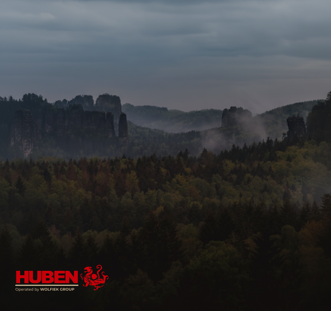 Huben Airguns operated by Wolfiek Group - brand logo on misty forest and mountain background
